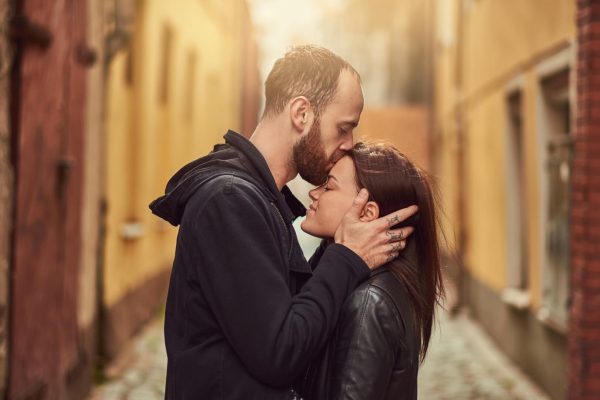 attractive-couple-bearded-man-brunette-girl-kissing-outside-old-european-street-background-Large